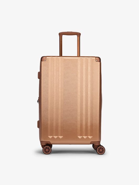 Studio product shot of front-facing CALPAK Ambeur medium 26-inch lightweight hardshell luggage with 360 spinner wheels in copper; LAM1024-COPPER