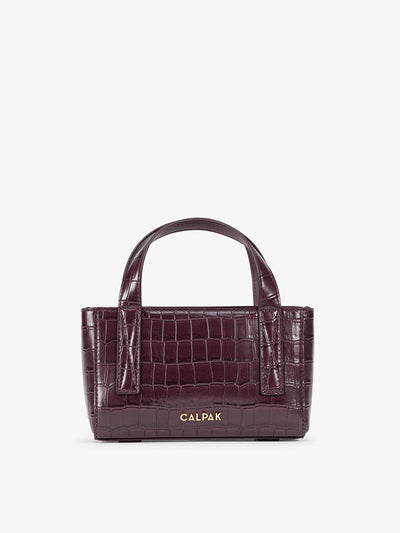 A CALPAK Haven Mini Crossbody Bag in deep red Dark Cherry crocodile-embossed with top handles on a plain white background; AMC2502-DARK-CHERRY-FAUX-CROC