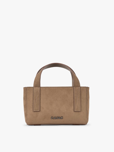 A CALPAK Haven Mini Crossbody Bag in brown Truffle Suede with top handles on a plain white background; AMC2502-TRUFFLE-FAUX-SUEDE