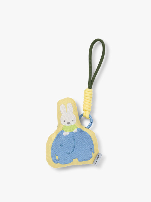 Plush Miffy x CALPAK Pluffy Bag Charm keychain with a yellow border and Miffy on a blue elephant on a white background; APLF2501-MIFFY-ELEPHANT