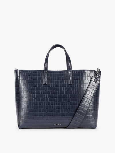 CALPAK Haven 16" Laptop Tote in blue Navy crocodile-embossed tote bag with top handles and a detachable shoulder strap, shown against a plain white background; ATO2102-NAVY-FAUX-CROC