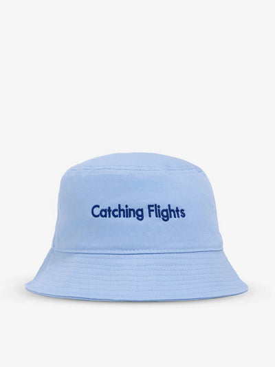 Light blue bucket hat with "Catching Flights" text embroidered on front.