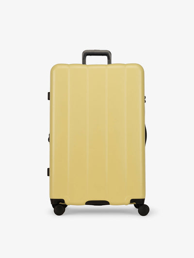 CALPAK yellow butter large luggage made from an ultra-durable polycarbonate shell and expandable by up to 2"; LCO1028-BUTTER
