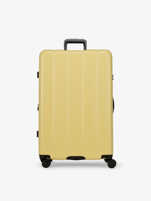 CALPAK yellow butter large luggage made from an ultra-durable polycarbonate shell and expandable by up to 2"; LCO1028-BUTTER