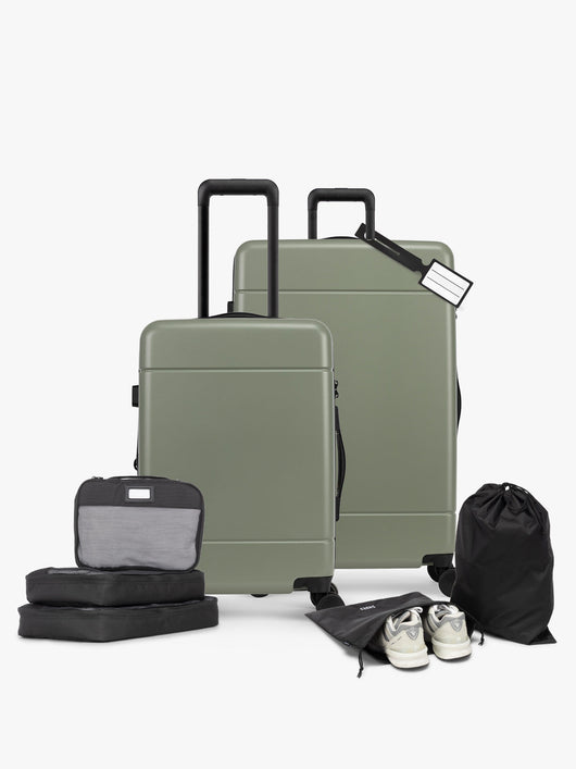 CALPAK Hue Starter Bundle in green Juniper that comes with Large and Carry On Luggage, Luggage Tag, Two Black Pouches, and Three Black Packing Cubes shown on a white background; LHU8000-JUNIPER