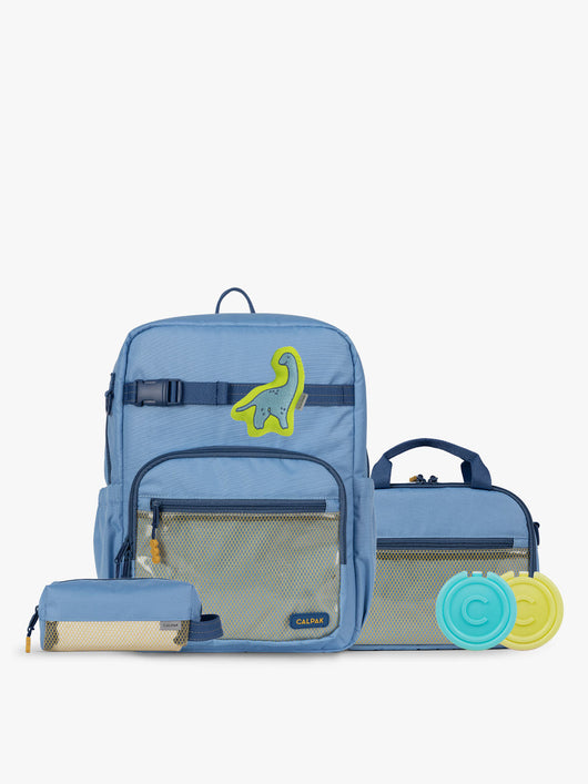 CALPAK Kids Collection Large Kids Backpack Bundle in Blue that includes Kids Lunch Bag, Kids Pencil Case, Rainbow Pluffy Bag Charm, and Set of 2 Ice Packs in a kid's room; BCKL5000-BLUE
