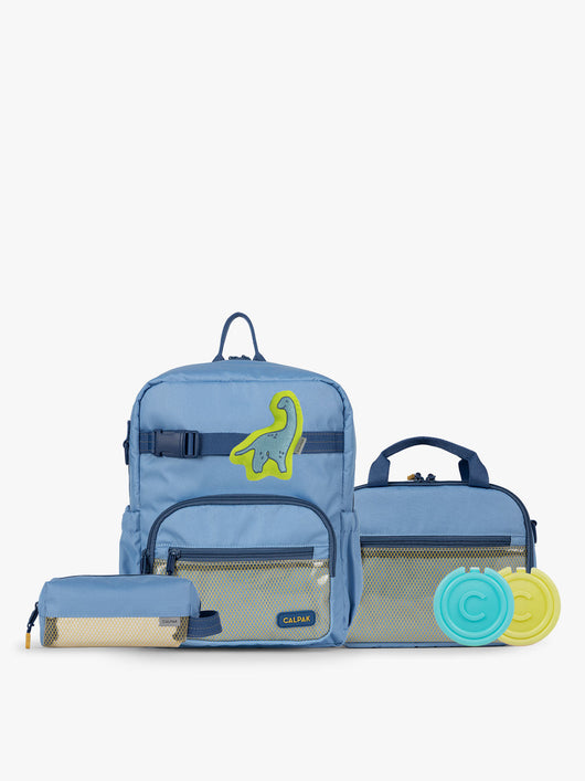 CALPAK Kids Collection Small Kids Backpack Bundle in Blue that includes Kids Lunch Bag, Kids Pencil Case, blue and green Dinosaur Pluffy Bag Charm, and Set of 2 Ice Packs in a kid's room; BCKS5000-BLUE