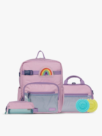 CALPAK Kids Collection Medium Kids Backpack Bundle in pink lavender Orchid Pink that includes Kids Lunch Bag, Kids Pencil Case, Rainbow Pluffy Bag Charm, and Set of 2 Ice Packs in a kid's room; BCKM5000-ORCHID-PINK