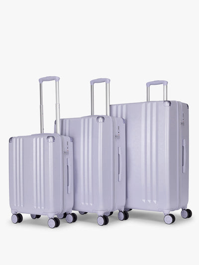 CALPAK Ambeur three piece luggage set in carry on, medium, and large sizes in light purple lavender with handles and spinner wheels on a white background; LAM3000-SEA-GLASS