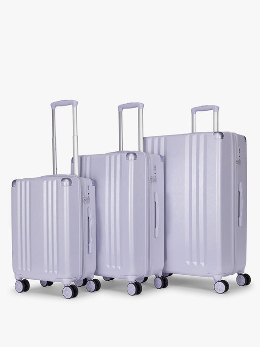 CALPAK Ambeur three piece luggage set in carry on, medium, and large sizes in light purple lavender with handles and spinner wheels on a white background; LAM3000-SEA-GLASS