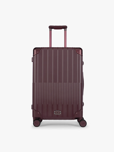 CALPAK Vault Luggage in Medium Dark Cherry deep red hard-shell spinner suitcase with a ribbed vertical design, shown from the front against a clean white background; LVT1024-DARK-CHERRY