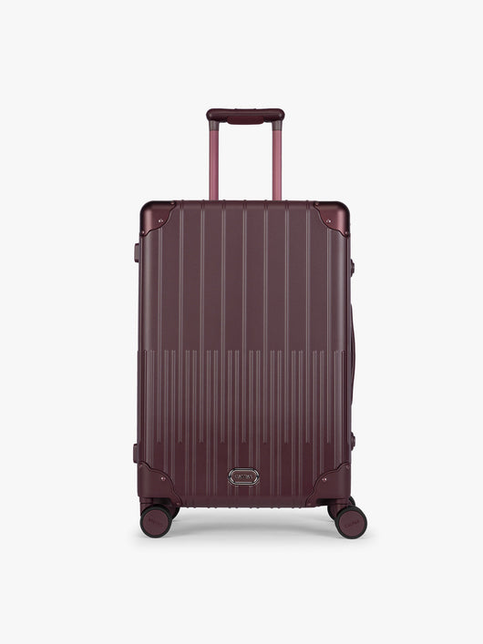 CALPAK Vault Luggage in Medium Dark Cherry deep red hard-shell spinner suitcase with a ribbed vertical design, shown from the front against a clean white background; LVT1024-DARK-CHERRY