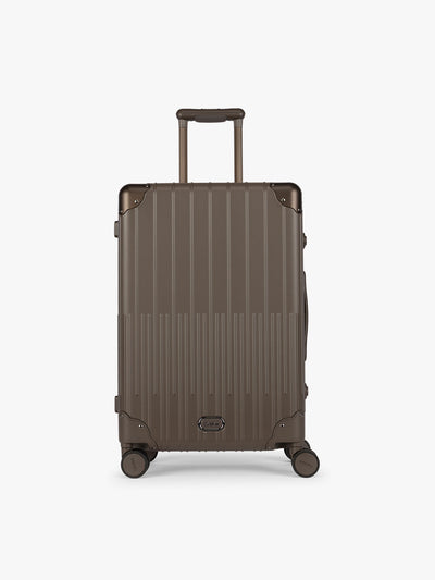 CALPAK Vault luggage brown Mushroom hard-shell spinner suitcase with a ribbed vertical design, shown from the front against a clean white background; LVT1024-MUSHROOM