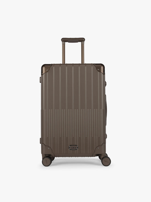 CALPAK Vault luggage brown Mushroom hard-shell spinner suitcase with a ribbed vertical design, shown from the front against a clean white background; LVT1024-MUSHROOM