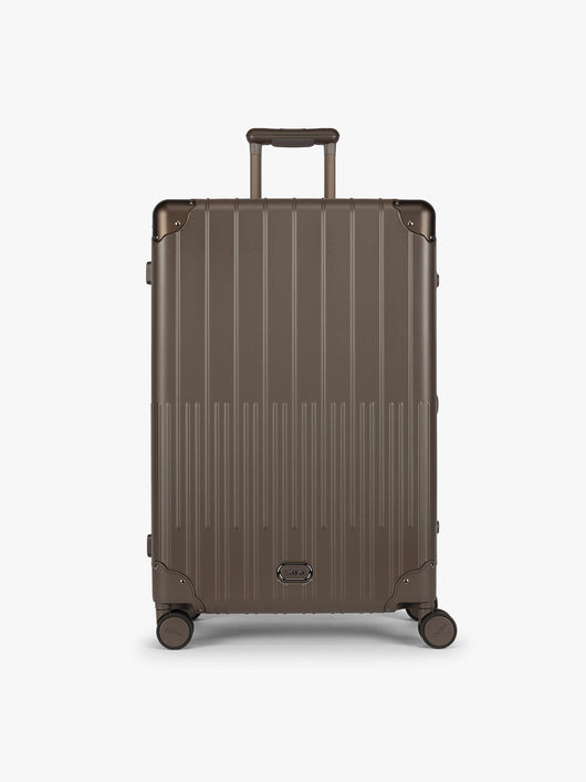 CALPAK Large Vault Luggage in brown Mushroom with hard-shell spinner suitcase with a ribbed vertical design, shown from the front on a light gray background; LVT1028-MUSHROOM
