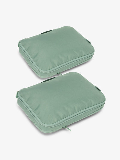 Two sage green rectangular packing cubes with zipper closures and carry handles.