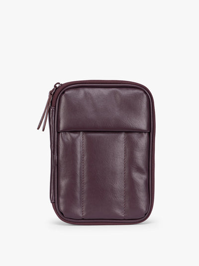 A deep burgundy Dark Cherry CALPAK Luka Zip Passport Wallet in vegan leather with a zippered top and a front pocket, shown on a plain white background; PZW2301-DARK-CHERRY-PU