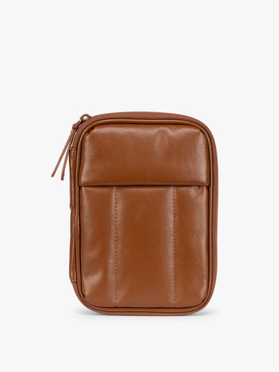 A light Honey Brown CALPAK Luka Zip Passport Wallet in vegan leather with a zippered top and a front pocket, shown on a plain white background; PZW2301-HONEY-BROWN-PU
