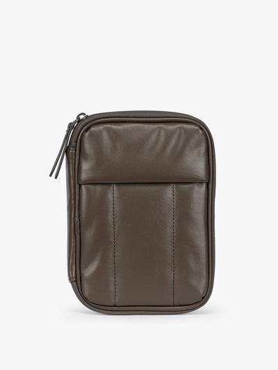 A dark brown Mushroom CALPAK Luka Zip Passport Wallet in vegan leather with a zippered top and a front pocket, shown on a plain white background; PZW2301-MUSHROOM-PU